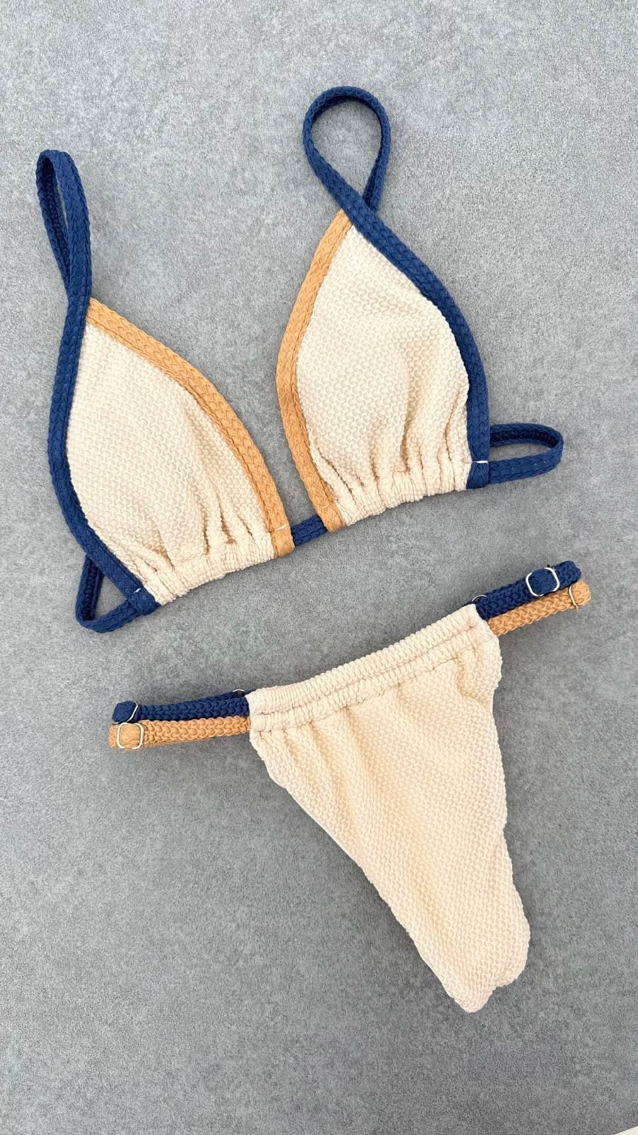 Sole bikini laid flat, in off-white, deep blue and sand